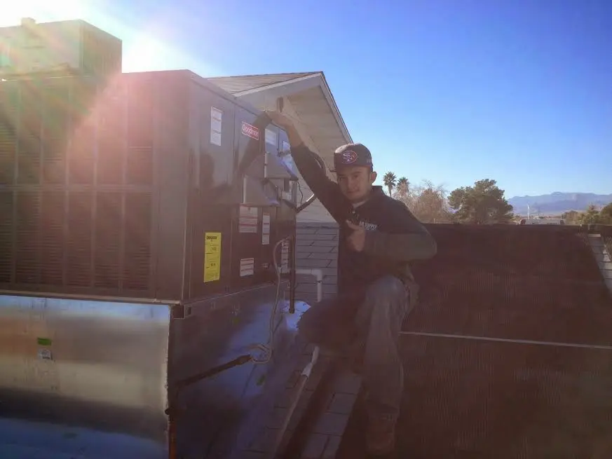 HVAC technician performing HVAC Inspection on a rooftop unit in Saratoga Springs